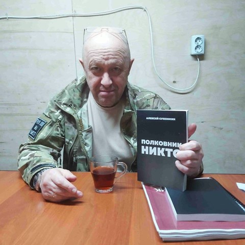 An image of Yevgeny Prigozhin, leader of the Wagner Group mercenaries, holding a Russian book in his left hand.