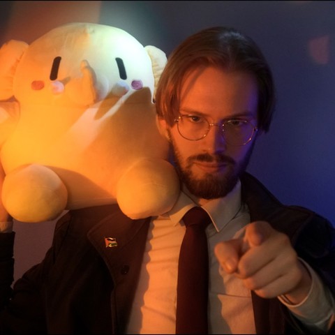 A picture of Erik Uden carrying a Mastodon on his shoulder and pointing into the camera