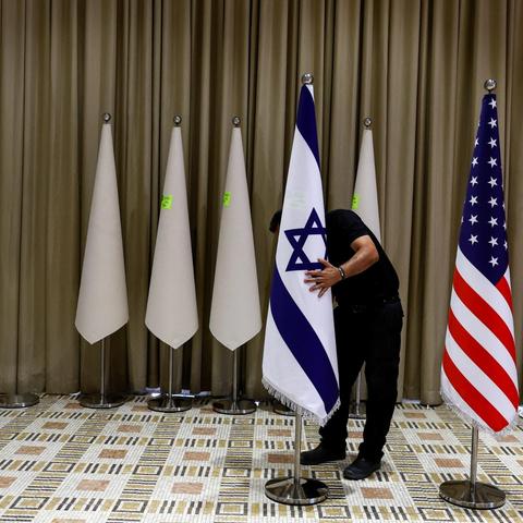 A picture of someone applying the Israel flag over a cone with many non-flag cones in the background