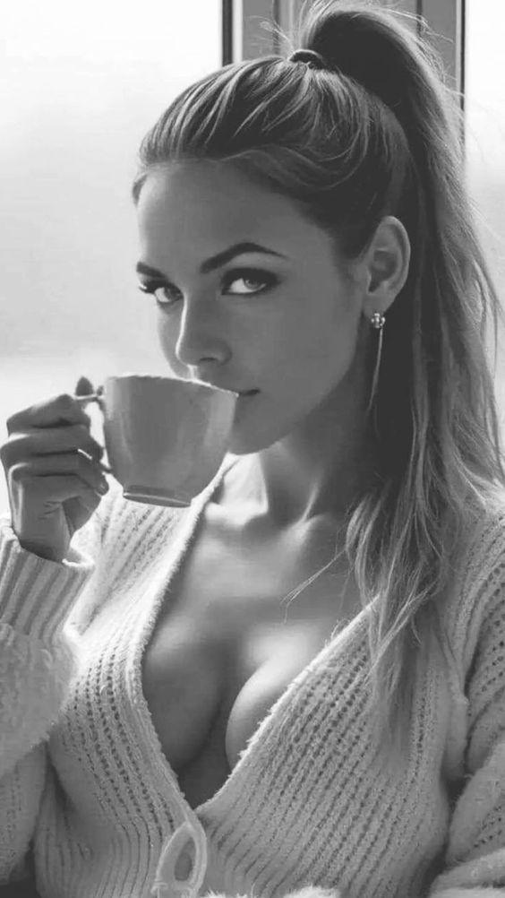 Nackte Frau in Strickjacke mit Kaffeetasse und wunderschönem Dekolleté