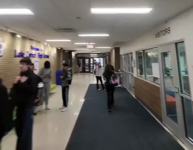A video of a guy running around school floors wearing a sign saying “I support ICE”