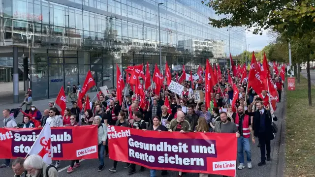 Ein Bild von den Sozialprotesten in Hannover vom Die Linke Block auf dem Erik Uden zu sehen ist mit zwei Die Linke Flaggen in der Hand.